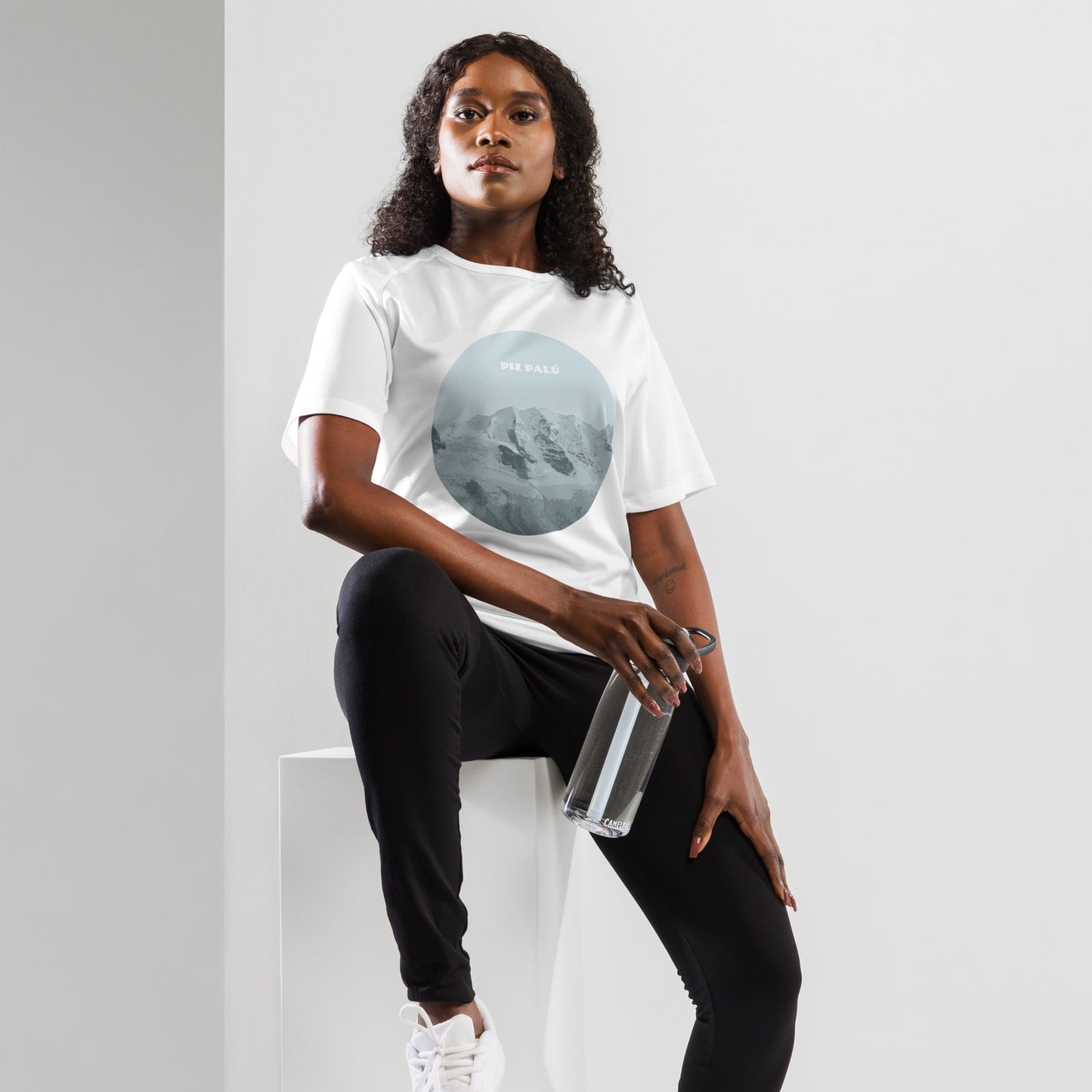 Weisses Damen Sport-Shirt mit Piz Palü Aufdruck in Hellblau, kombiniert mit schwarzer Trainingshose und weißen Sportschuhen.