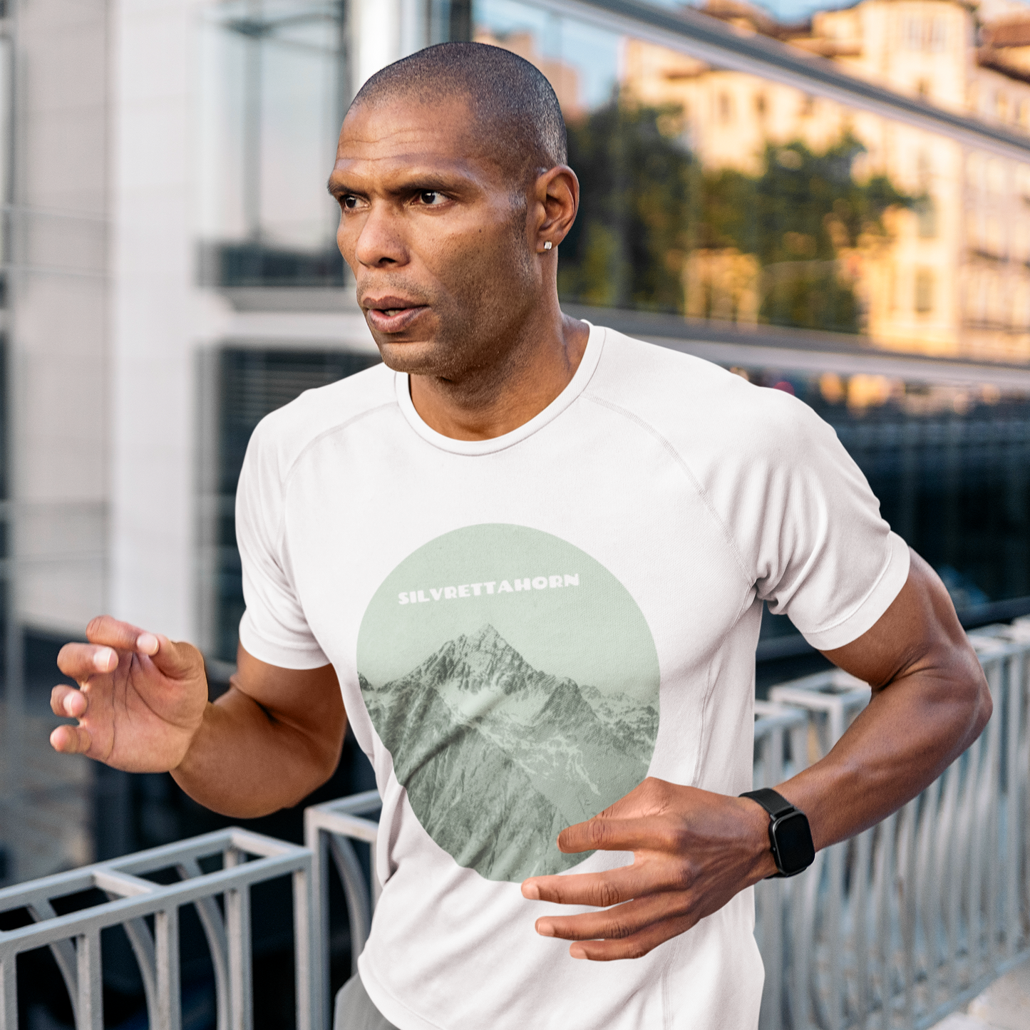 Grünes Herren-Sport-Shirt mit Silvrettahorn-Print, getragen von einem Jogger.