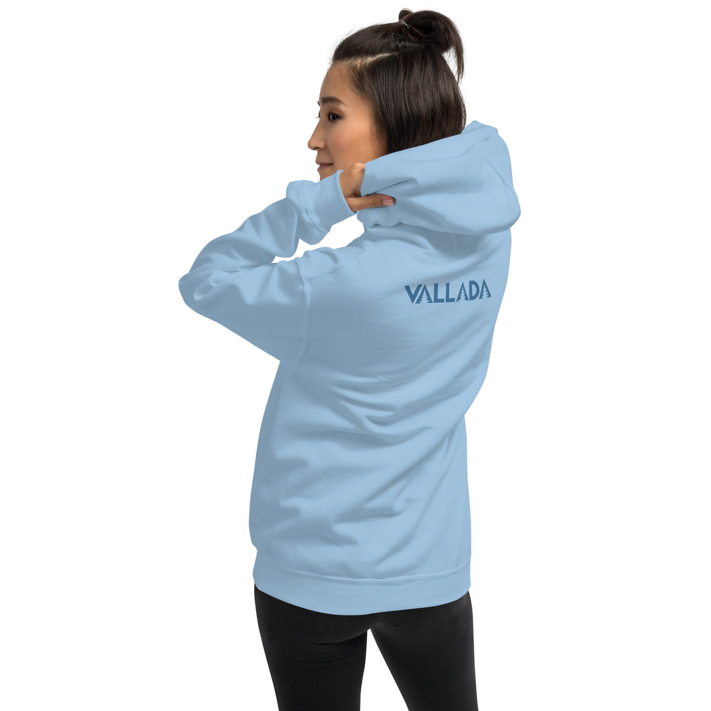 Diese Wanderfreundin trägt einen hellblauen Hoodie aus der Säntis-Collection von Vallada. Sie steht mit dem Rücken zur Kamera, so dass wir das Vallada-Logo sehen.