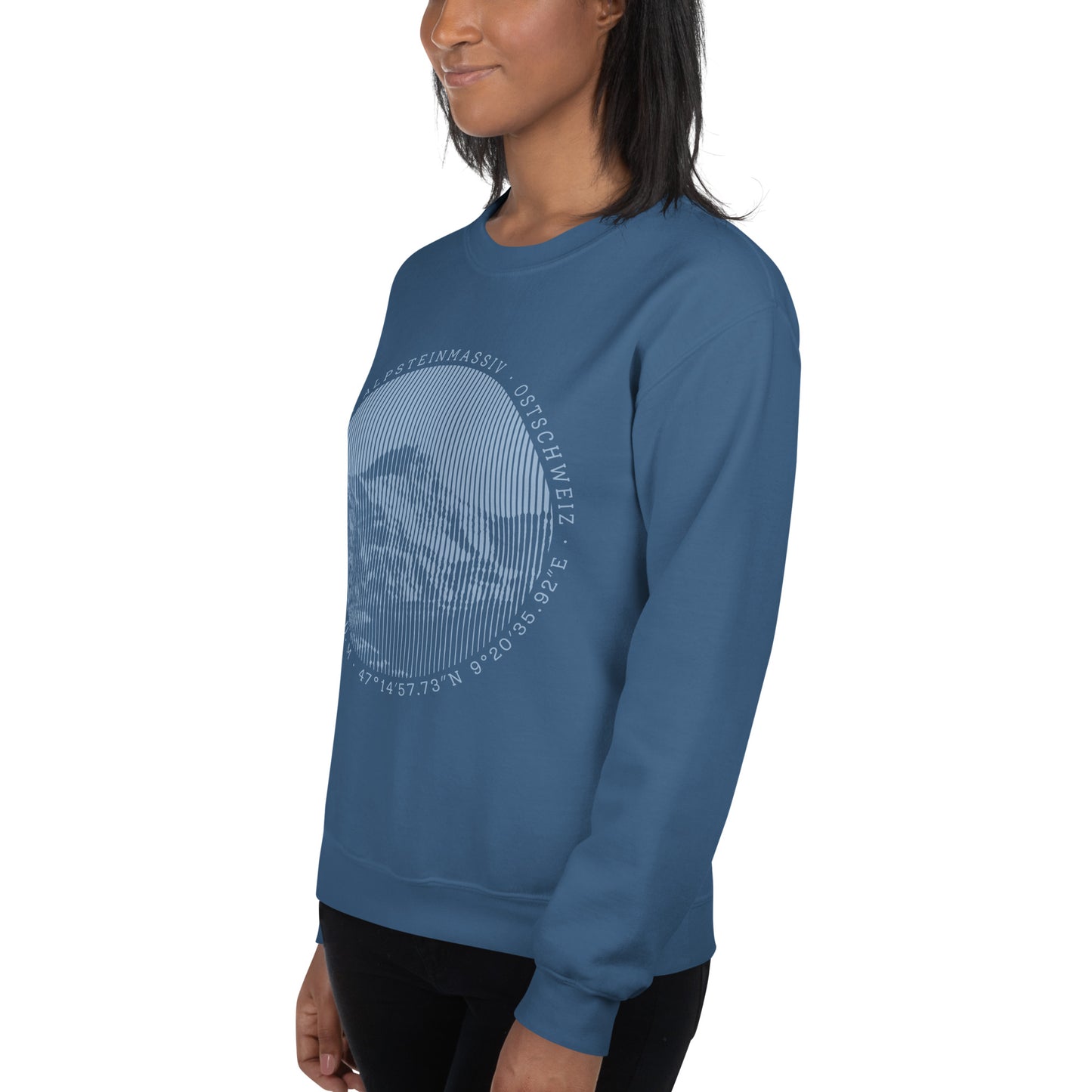Diese Bergbegeisterte trägt ein indigofarbenes Sweatshirt von Vallada mit einem Aufdruck des Säntis-Gipfels. Dieses Sweatshirt ist ein Statement für ihren Enthusiasmus für diesen Berg in den Appenzeller Alpen.