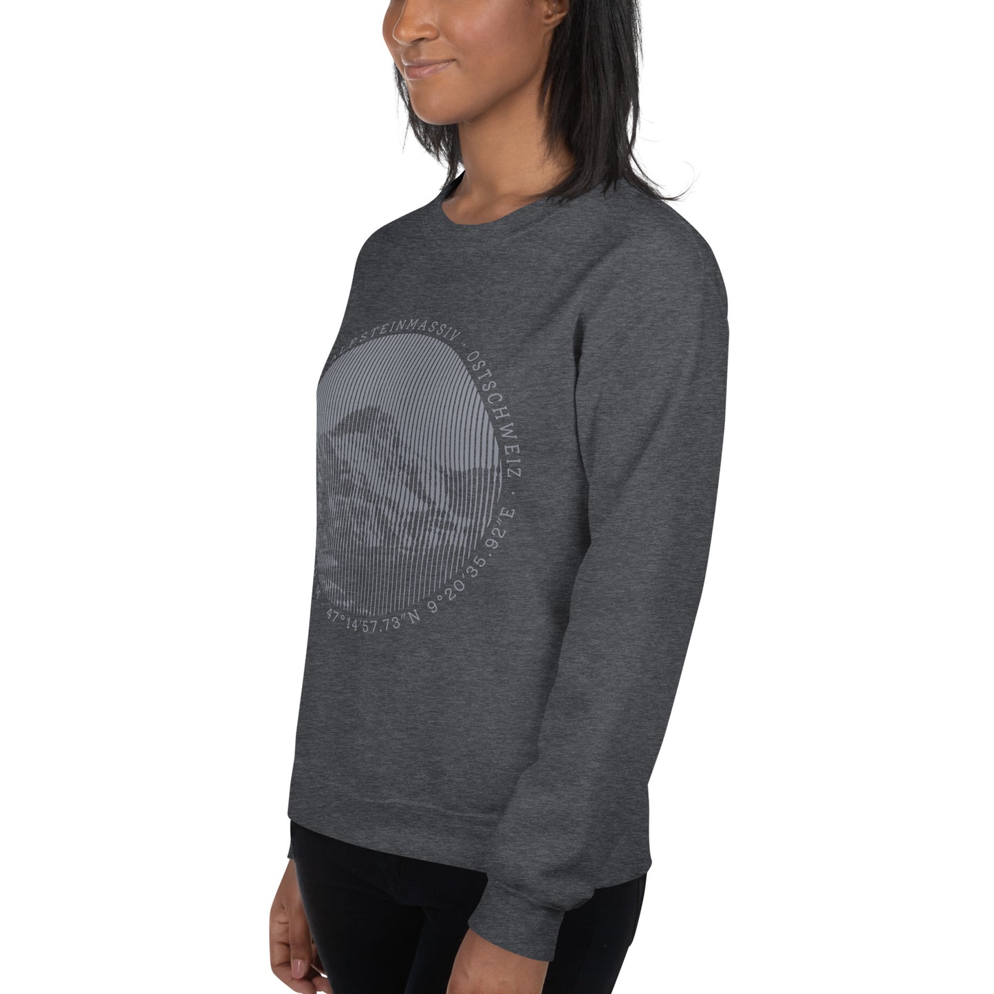 Diese Bergbegeisterte trägt ein dunkelgrau meliertes Sweatshirt von Vallada mit einem Aufdruck des Säntis-Gipfels. Dieses Hoodie ist ein Statement für ihren Enthusiasmus für diesen Berg in den Appenzeller Alpen.