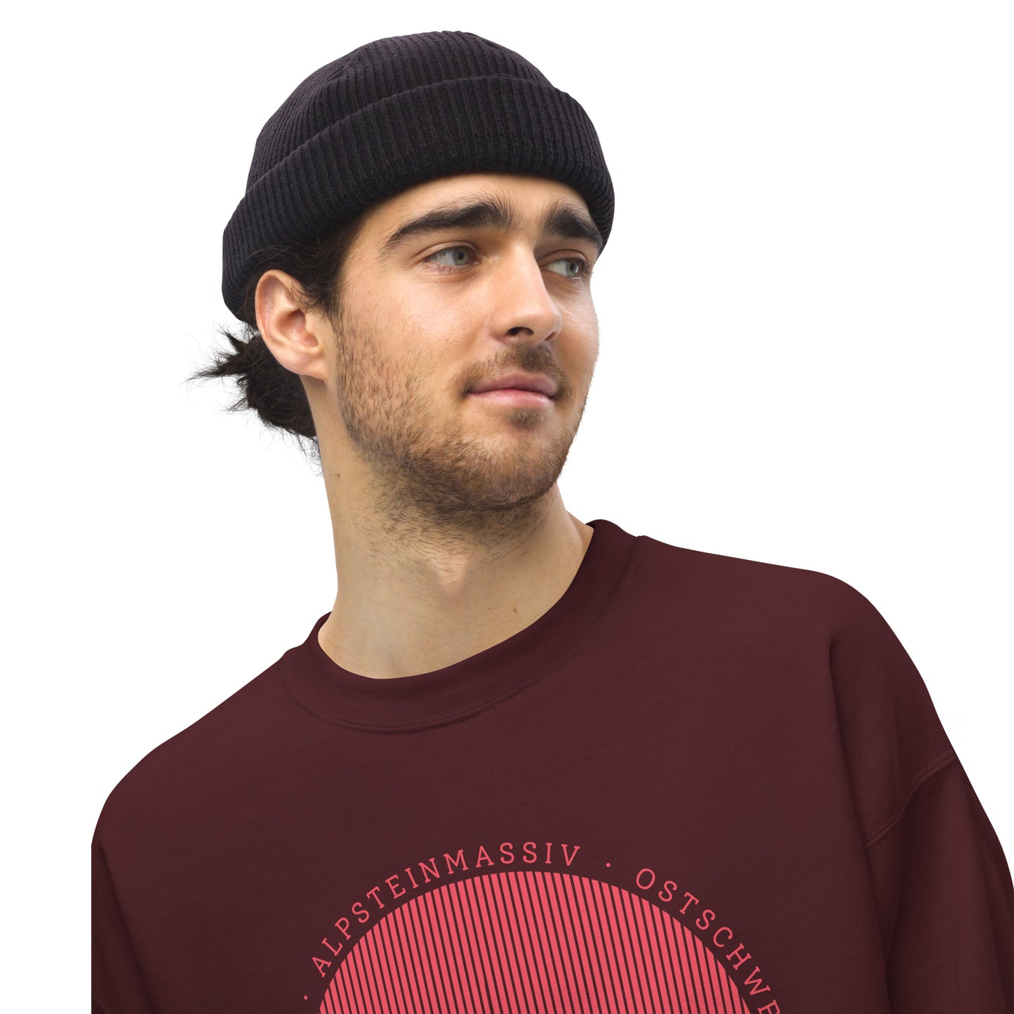 Junger Mann mit Dreitagebart trägt ein kastanienbraunes Sweatshirt mit Säntis.