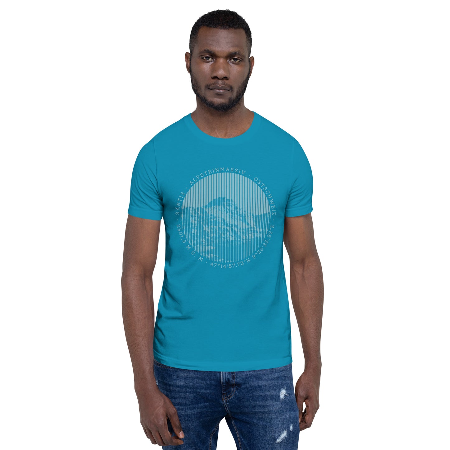 Wir sehen einen jungen Mann in Jeans und T-Shirt. Der Print seines türkisfarbenen T-Shirts zeigt den Säntis.