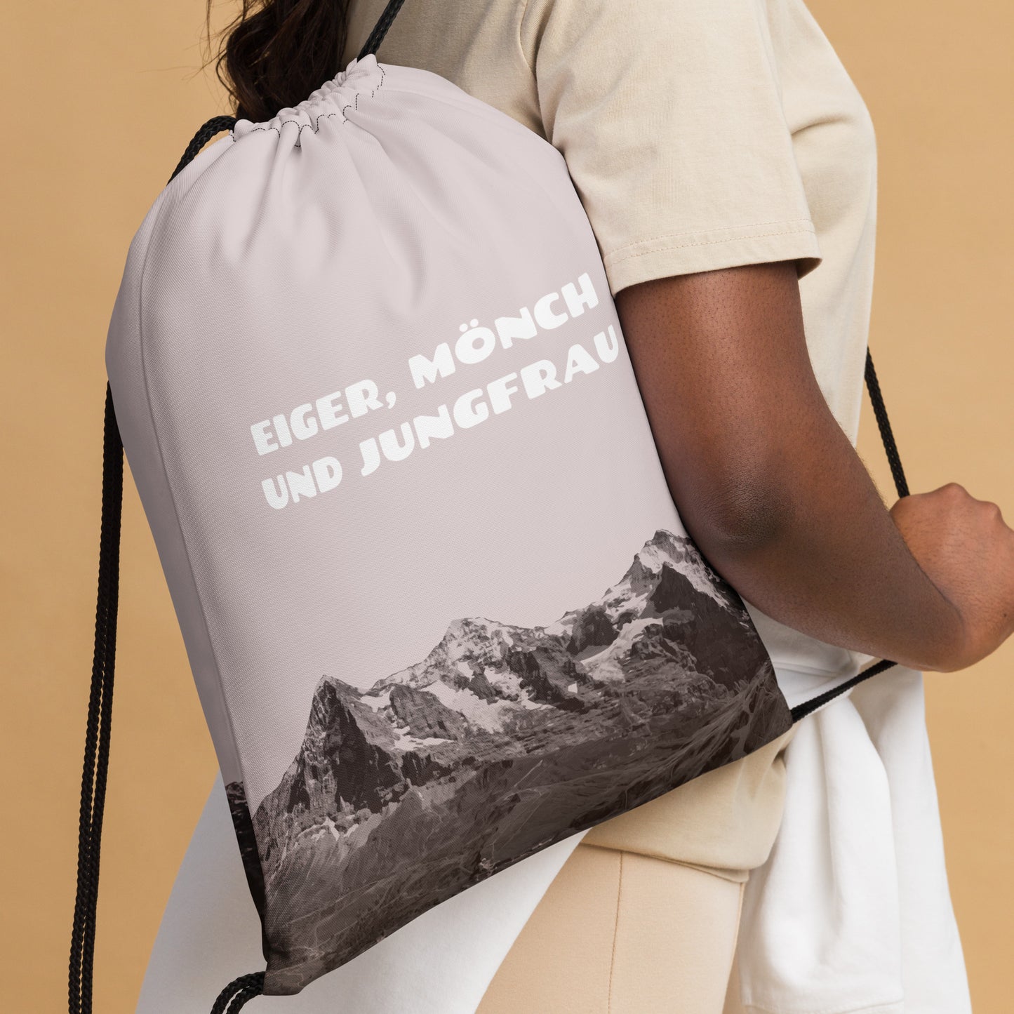 Rosa Turnbeutel mit Bergpanorama mit Eiger, Mönch und Jungfrau. Das Säckli wird an der Kordel über der Schulter getragen.