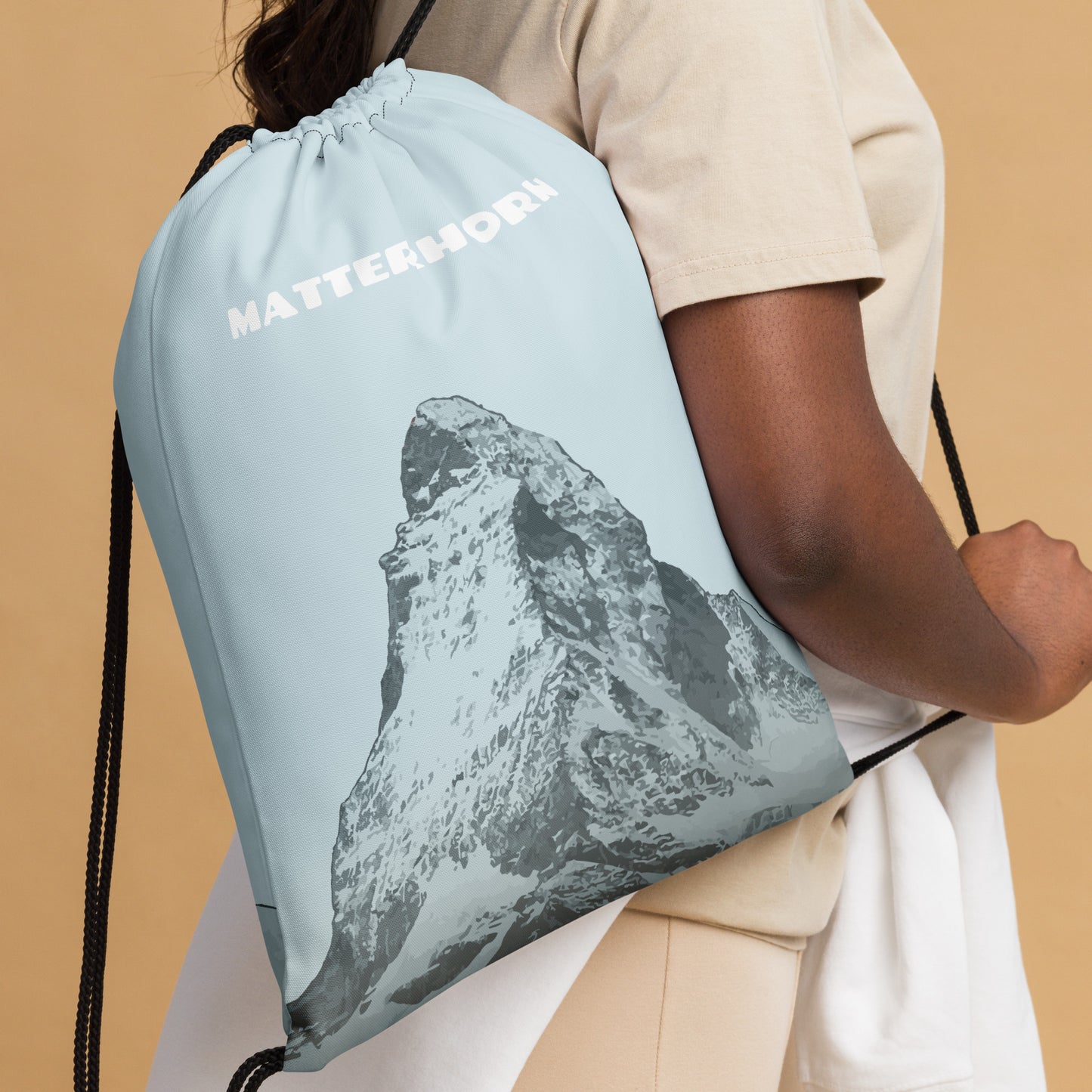 Blauer Kordelzugbeutel mit Matterhorn-Print, getragen über der Schulter.