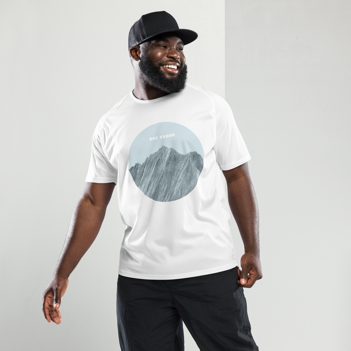 Fröhlicher Mann mit einem weissen Herren-Sport-Shirt mit einem Print der den Piz Terri in Graubünden zeigt. 