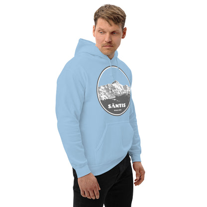 Der Herr trägt einen hellblauen Hoodie mit Berg-Motiv.