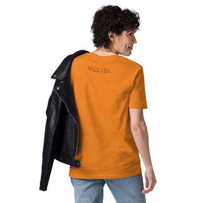 Sie trägt ein oranges Damen T-Shirt aus der Säntis-Collection von Vallada. Sie steht mit dem Rücken zur Kamera, so dass wir das Vallada-Logo sehen.