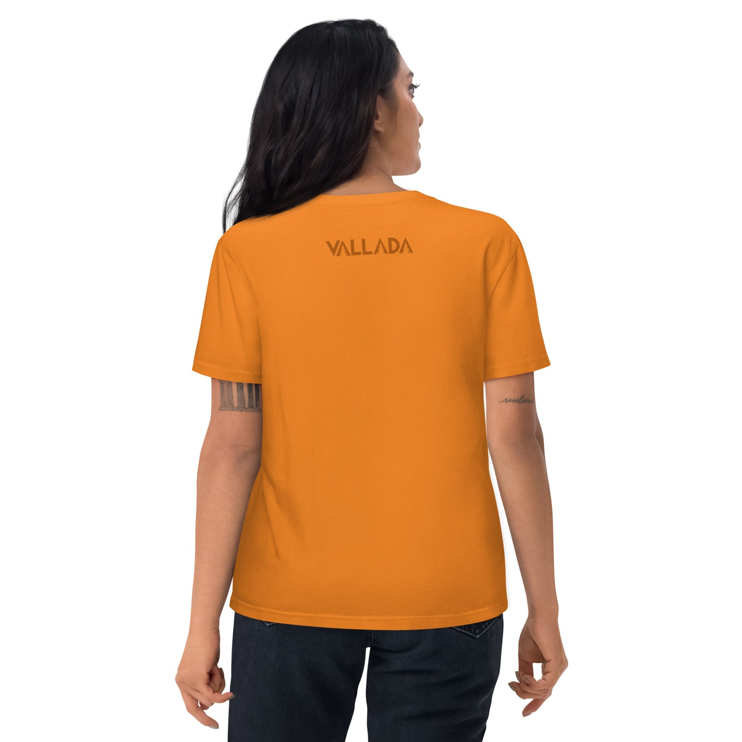 Diese Wanderfreundin trägt ein oranges Damen T-Shirt aus der Säntis-Collection von Vallada. Sie steht mit dem Rücken zur Kamera, so dass wir das Vallada-Logo sehen.