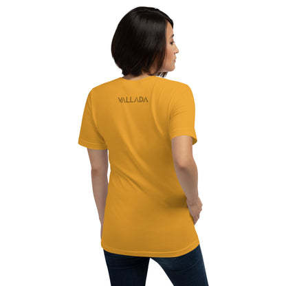 Diese Wanderfreundin trägt ein senffarbenes Damen T-Shirt aus der Säntis-Collection von Vallada. Sie steht mit dem Rücken zur Kamera, so dass wir das Vallada-Logo sehen.