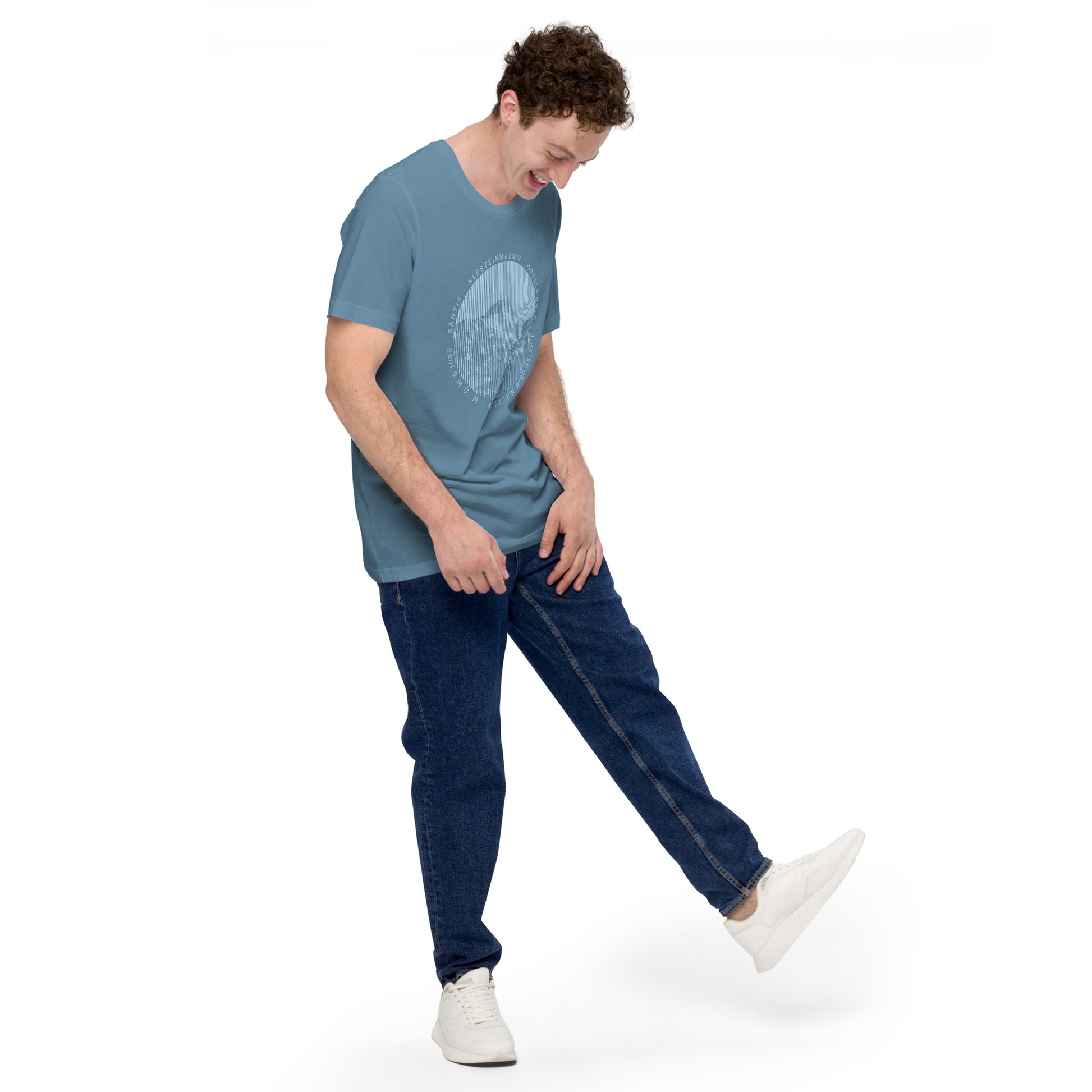 Ansicht eines jungen Mannes mit stahlblauem T-Shirt aus der Säntis-Collection. Zum T-Shirt trägt er Jeans und weisse Sneakers.