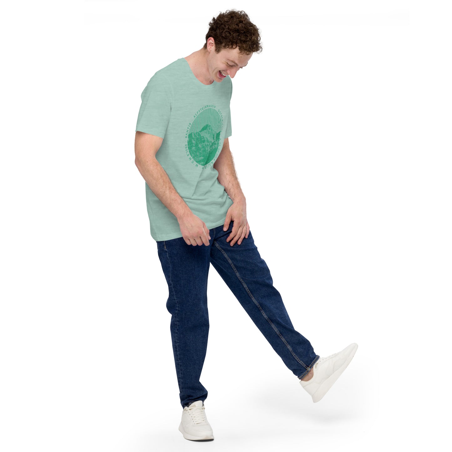 Junger Mann mit taubenblauem T-Shirt, Jeans und weissen Snakers. Das T-Shirt, dass er trägt ist von VALLADA und zeigt den Berg Säntis.