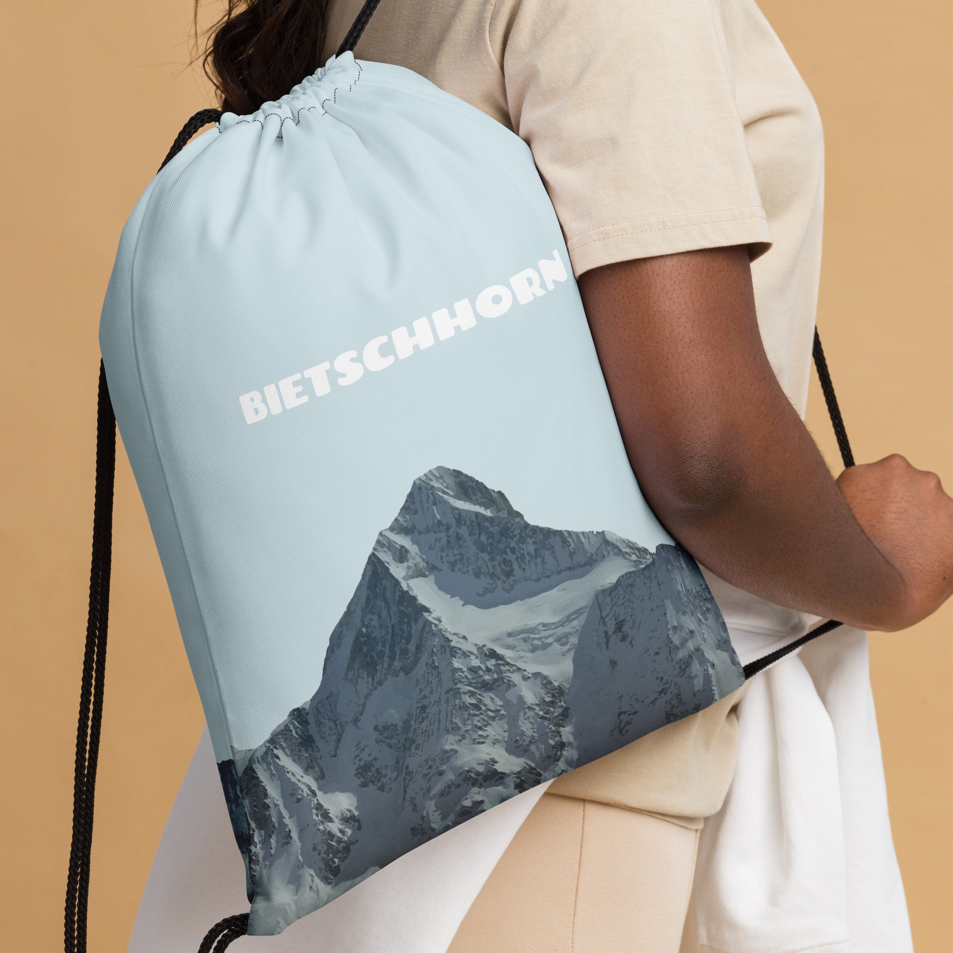 Hellblauer Kordelzugbeutel aus Polyester mit Bietschhorn-Print, getragen über der Schulter.