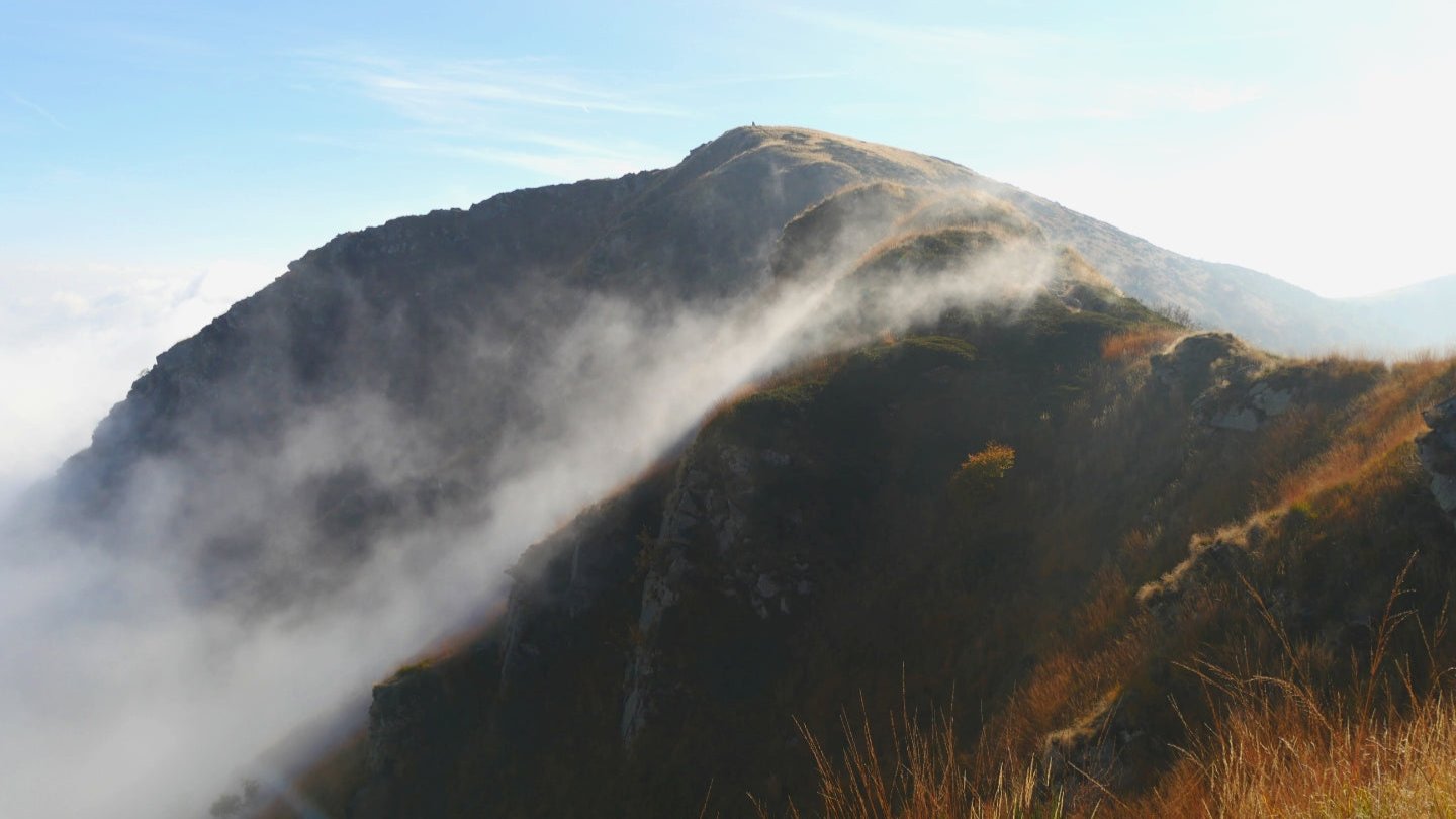 Die Wolken kriechen den Bergkamm hinauf.